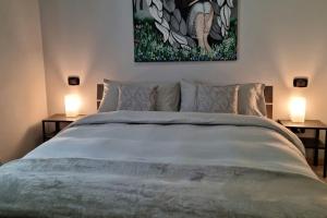 罗韦雷托Apartments via Roma的一间卧室配有一张大床和两盏灯