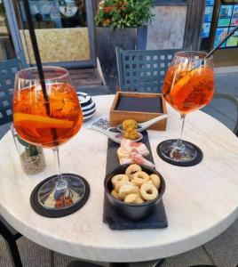 罗韦雷托Apartments via Roma的两杯酒杯和一碗桌上的食物