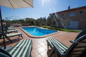 SilsCatalunya Casas Tranquil Costa Brava Retreat with private suite!的一个带草坪椅和遮阳伞的游泳池