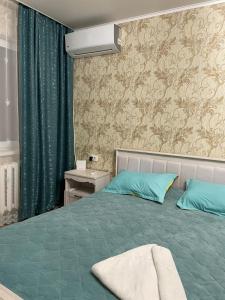 乌拉尔斯克Домашний уют в центре的一间卧室配有一张带蓝色枕头的床
