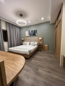 RaḩīmahLolia Hotel的酒店客房配有一张床铺和一张桌子。