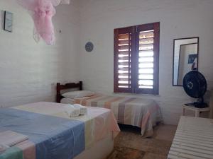 泰巴Casa dos Ximenes - Beira Mar da Taíba - Ótima localização的客房设有两张床和一扇窗户。