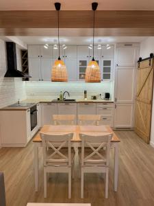 克罗斯诺APARTAMENTY GUZIK 22的厨房配有木桌和椅子