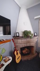 门多萨Mora Hostel的带壁炉的客厅里的吉他