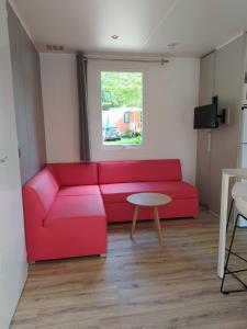 坎佩尔Mobile Home tout confort C13 Domaine de Lanniron的客厅配有红色的沙发和桌子