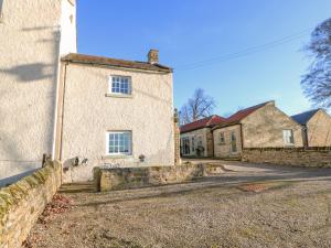 GillingThe Stable, Sedbury Park Farm的一座古老的石屋,有石墙和两栋建筑