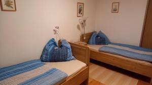 圣斯蒂凡安德Apartment Komar的两张带蓝色枕头的床