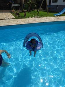 圣罗克Recanto Kamei-Piscina climatizada的穿着救生衣的孩子在游泳池里