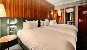 卡萨布兰卡Boutique Hotel Gauthier Restaurant Terrasse的酒店客房设有两张床和一张桌子。