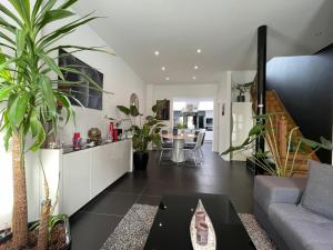 WemmelModern 1BR house near Heysel, Expo, Palais 12, Atomium, UZVUB et stade Roi Baudouin的带沙发和一些植物的客厅