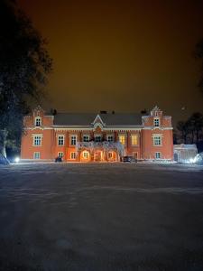 RynkówkaZamek Rynkówka的一座橙色的大建筑,晚上灯亮