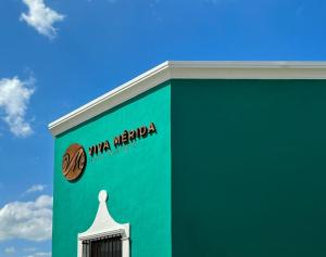 梅里达Viva Merida Hotel Boutique的绿色建筑,上面有比萨玛格丽塔标志