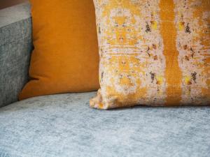 洛夫特胡斯乌兰斯万酒店的坐在沙发上的一个橙色枕头