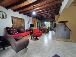 图努扬Casa de campo de piedra的客厅配有红色的沙发和桌子