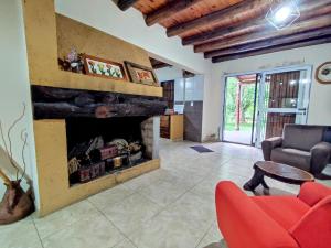 图努扬Casa de campo de piedra的客厅设有壁炉和红椅