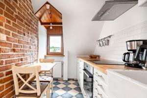 兹戈热莱茨Blick Apartments - Riverview Studio Apartment的厨房配有桌子和砖墙