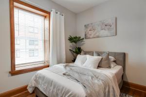 里士满Cozy Historic Family Home in the Heart of Richmond的一间卧室配有一张带白色床单的床和一扇窗户。