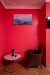 WakisoKaray Apartments的一间设有红色墙壁、桌子和椅子的房间