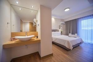 雅典Anixi Hotel by AP的浴室设有床、水槽和镜子
