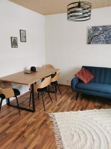 LieserbrückeRiverside Appartements的一间配备有蓝色沙发和一张桌子的用餐室