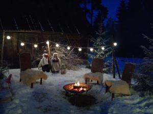 拉克韦雷Käänu puhkemaja的几个站在雪中的人,带着火
