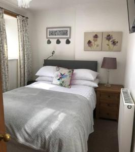 邓弗里斯Abbey Green, New Abbey, Dumfries and Galloway的一间卧室配有带白色床单和枕头的床。