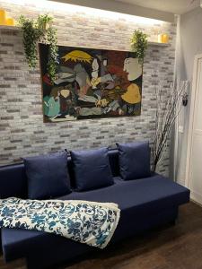 马德里Coqueto apartamento muy céntrico的客厅里一张蓝色的沙发,上面有绘画作品