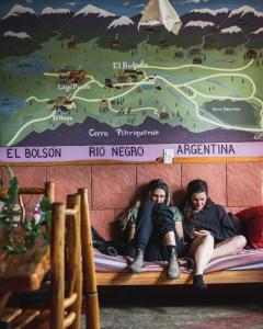埃博森Ankatu Hostel的两个人坐在一张地图下的床上
