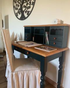 MardorMaison Mard'Or Chambre Forêt的一个带椅子的桌子,放在带时钟的房间里