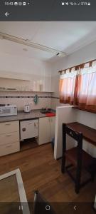 戈多伊克鲁斯Monoambientes Arizu的厨房配有白色橱柜和桌子