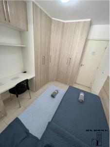 若昂佩索阿MSHome - Apartamento Térreo com Varanda e Mobiliado的一间卧室配有蓝色的床和一张书桌