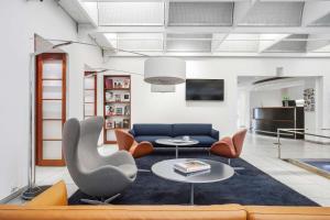 哥本哈根The Huxley Copenhagen, BW Premier Collection的客厅配有蓝色的沙发和橙色椅子