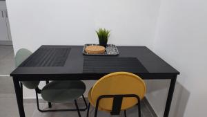 海法Studio Apartment 12 Minutes from Bahai's garden的一张带黄色椅子的黑桌和一盘食物