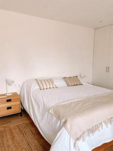 何塞伊格纳西奥Casa de mar - José Ignacio的白色卧室设有大床和床头柜