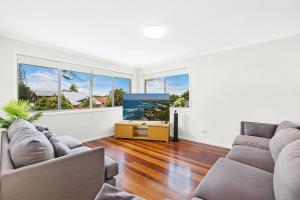 黄金海岸Ultimate Burleigh Beach House Family Retreat! - 5 BEDROOMS的客厅配有两张沙发和一台电视机