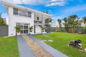 黄金海岸Ultimate Burleigh Beach House Family Retreat! - 5 BEDROOMS的院子里有狗像的白色房子