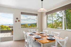 陶波Great Lake Getaway - Taupo的一间带桌椅和窗户的用餐室