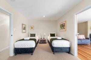 陶波Great Lake Getaway - Taupo的一间客房配有两张床和一张沙发
