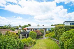 陶波Great Lake Getaway - Taupo的一座带花园和庭院的房子