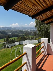 里奥班巴Hostería El Troje Experience的阳台享有带游乐场的房屋的景致。