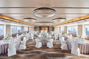 大阪大阪日航国际酒店的宴会厅配有白色的桌子和白色的椅子