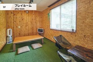 富士吉田市MtFuji Guest House Kikkake的客房设有书桌、电视和桌子。