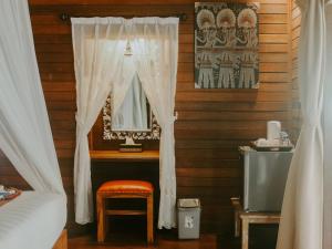 蓝梦岛Garden Cottage Lembongan & Hostel的一间卧室配有床、镜子和凳子