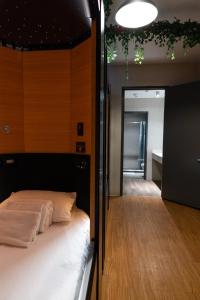 纽约Nap York Central Park Sleep Station的一间卧室配有一张床,另一间卧室设有走廊