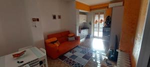 都灵Casa dei Nonni - comodo Metro e Stadio Juve的一间带橙色沙发的客厅和一间厨房