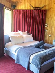 芬戈The Beach Cabin的一间卧室配有一张带红色窗帘的大床