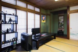 东京Mochida's Guest House的一间配备有一张书桌的房间,电脑在里面