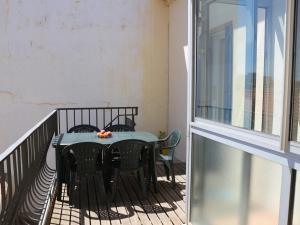 滨海巴纽尔斯Appartement Banyuls-sur-Mer, 3 pièces, 5 personnes - FR-1-309-58的阳台上配有一张黑色的桌子和椅子