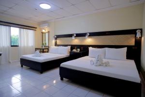 塔比拉兰道戴梦得餐厅及酒店的酒店客房,配有两张带白色床单的床