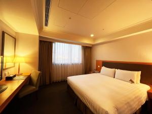 台南台南富华大饭店的酒店客房设有一张大床和一张书桌。
